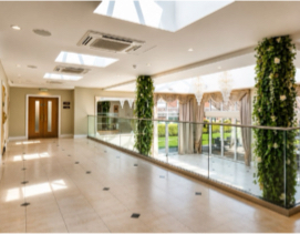 The bright, plant-filled atrium inside the Ramada Park Hall Hotel & Spa